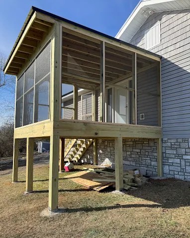 Newly built elevated screened porch with fresh pressure-treated framing