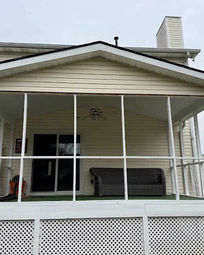Finished screened porch addition with white posts on the back of a home